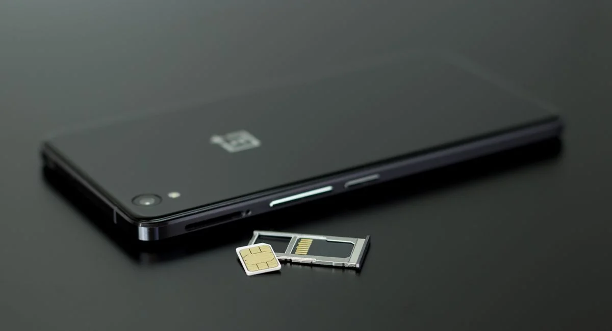Close-up of a smartphone with a SIM card and memory card, showcasing modern technology.