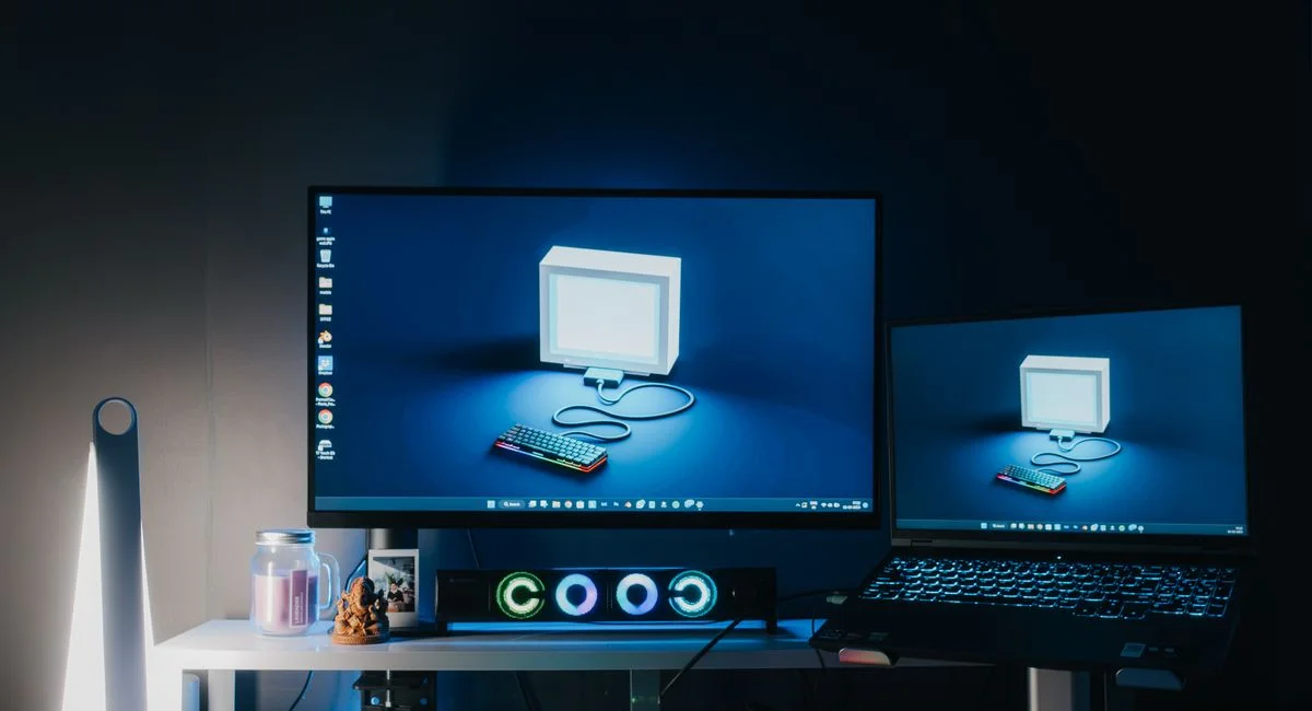 A sleek home office setup featuring dual monitors, RGB lighting, and tech gadgets, ideal for gaming or work.