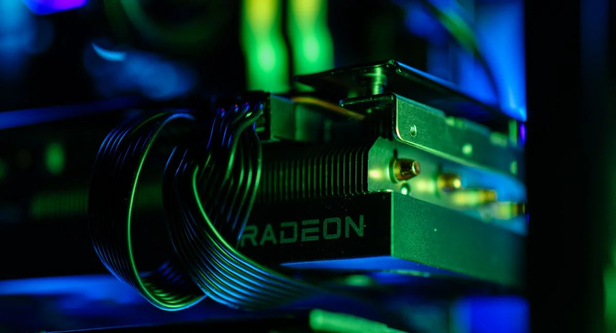 Detailed close-up of a gaming PC's Radeon graphics card with vibrant RGB lighting, showcasing cables and hardware.