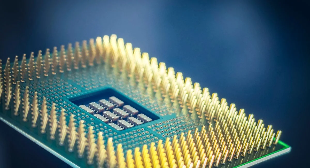 High-resolution macro shot of a computer CPU chip with gold pins against a blue background.