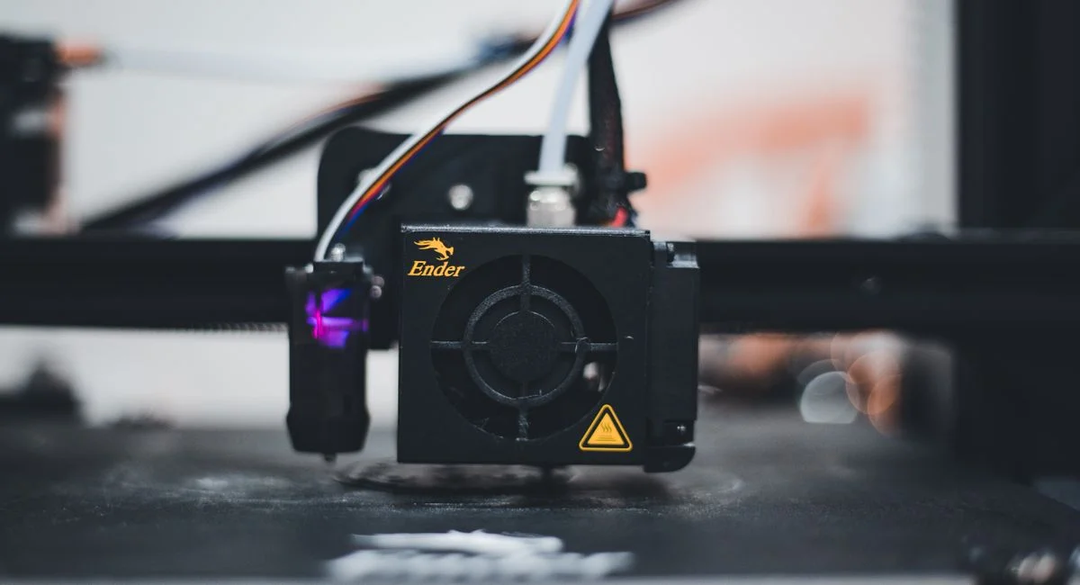 Detailed view of a 3D printer nozzle during the printing process, showcasing advanced technology.