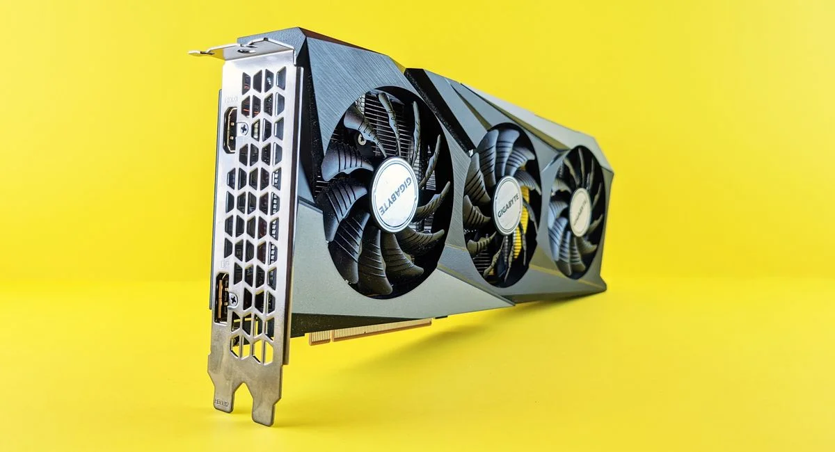 Close-up of a modern graphics card on a vibrant yellow background highlighting its design and technology.
